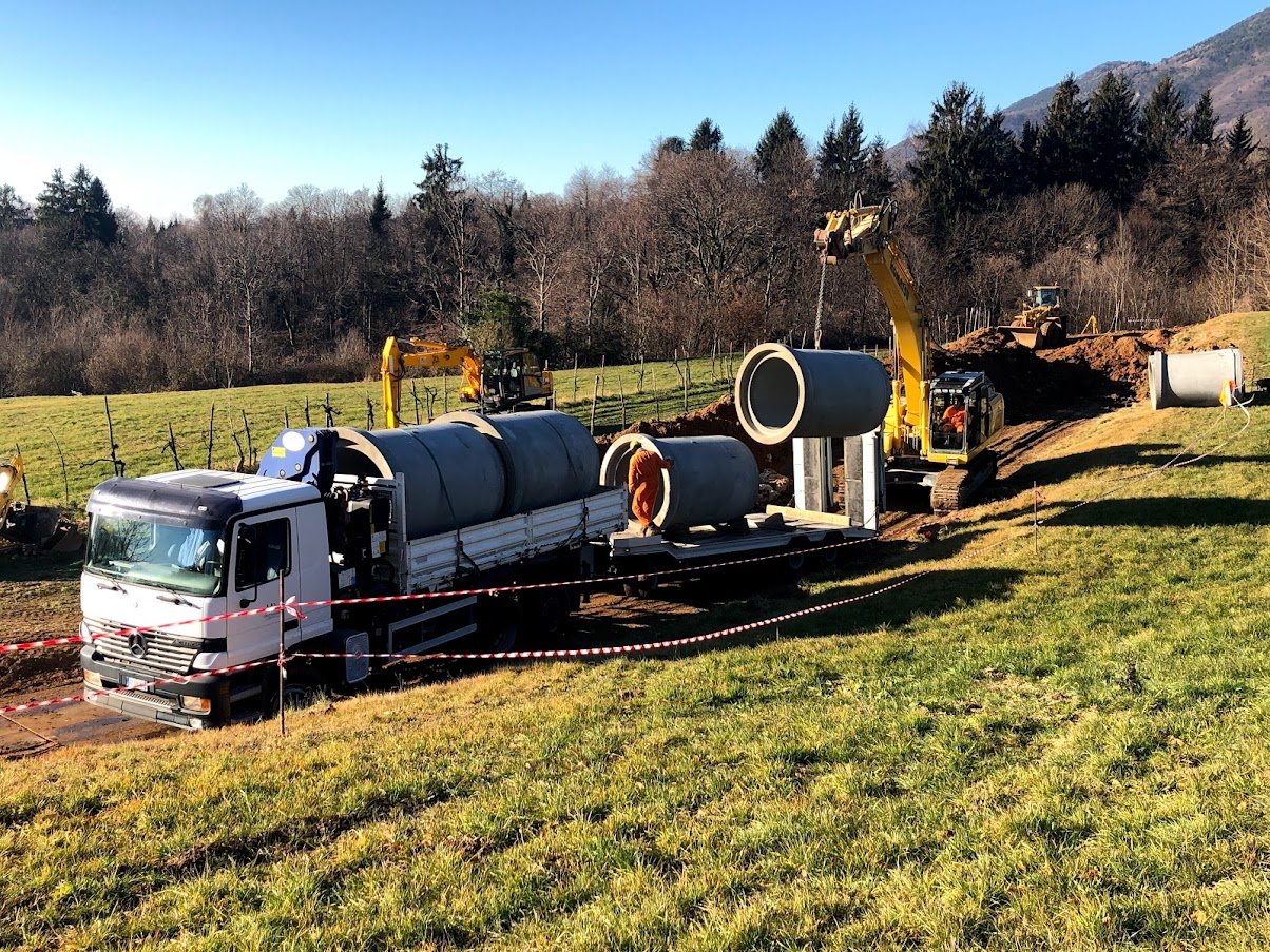 Cantiere di posa tubazioni in cemento di grande diametro per fognatura